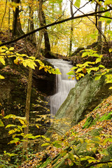 Cascade Falls among leaves and moss covered boulders in Nelson Ledges State Park on a beautiful Autumn day