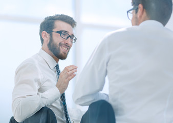 rear view.business colleagues discuss something sitting at the Desk.