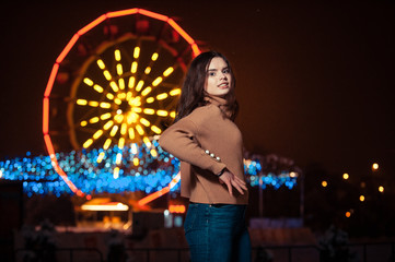 Young girl posing in a amusement park on a winter night.