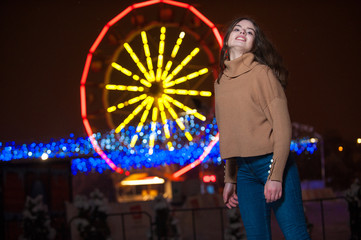 Obraz premium Young girl posing in a amusement park on a winter night.