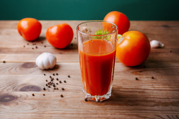 A glass of delicious tomato juice, fresh tomatoes and garlic