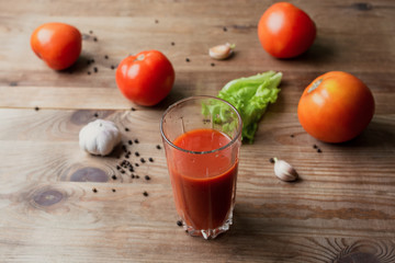 A glass of delicious tomato juice, fresh tomatoes and garlic