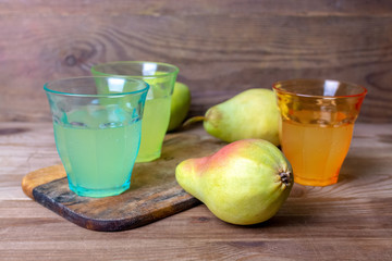 soda pop in a glass cup next to a pear