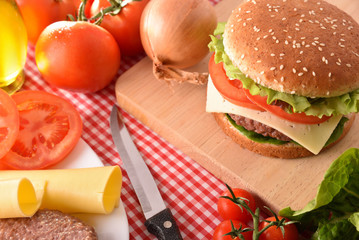 Homemade burger with ingredients on table elevated top