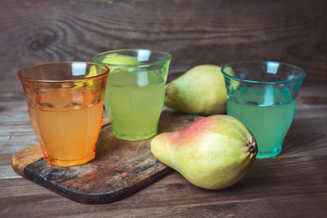 soda pop in a glass cup next to a pear