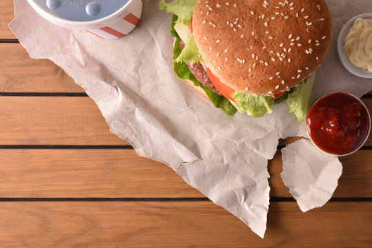 Background with burger with soda and souces on table top