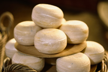 Multiple cheeses on a plate and basket outside on a christmas market