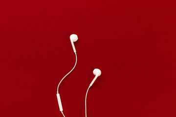 White earphones on red background