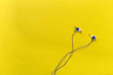 black earphones on colour background, top view