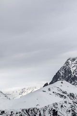 Fototapeta na wymiar Snowy mountain pass and cloudy gray sky at winter