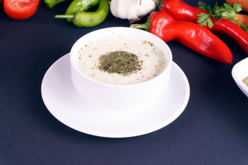 Creamy Mushroom Soup in a white bowl on dark table. . 