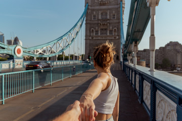 couple follow me concept on the tower bridge in london