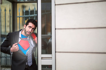 Young businessman acting like a super hero and tearing his shirt