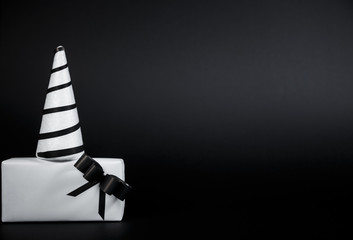 Fototapeta premium White Christmas tree and Gift box for special day isolated on black background.