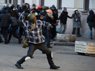 Riots, fire in the city, protester throws a stone