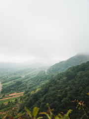 Fototapeta premium Moody landscape: hilly terrain covered in clouds and fog