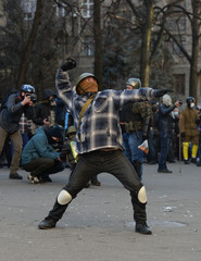 Riots, fire in the city, protester throws a stone