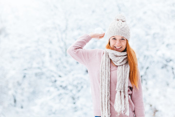 Young woman with snowball in the park