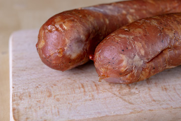 Tasty, fresh sausage smoked on the kitchen table. Tasty meats prepared for home celebration.