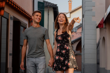 young couple in love looking at shop window in an alley in ascona during sunset