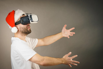 Man in virtual reality goggles and santa hat
