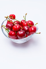 Fototapeta na wymiar The glass bowl filled with ripe cherries