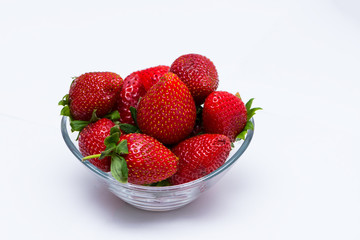 The glass bowl filled with red strawberries