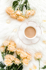 Composition of pastel tea rose bouquet flowers and a Cup of cocoa on white background. Floral background. Flat lay, top view.  