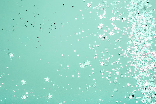 Silver and pink star glitter on teal pastel background. Festive concept. Place for design.