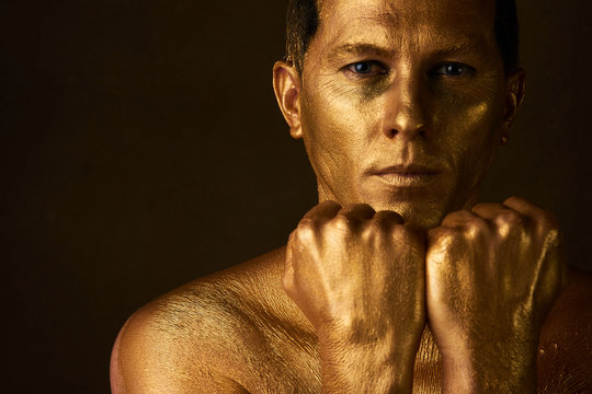 Body Art Paint With Gold On Face Of Man Over Dark Background 