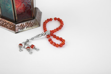Muslim lamp and prayer beads on white background. Space for text