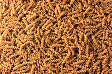 Top view Wholemeal pasta fusilli raw organic whole grain on a rustic wooden. Whole wheat pasta