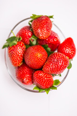 The glass bowl filled with red strawberries