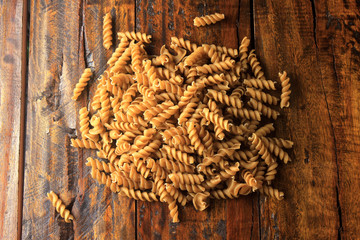 Top view Wholemeal pasta fusilli raw organic whole grain on a rustic wooden. Whole wheat pasta