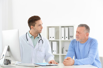 Doctor working with mature patient in hospital