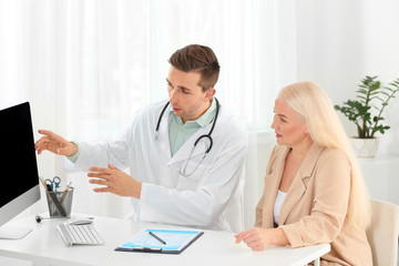 Doctor working with mature patient in hospital