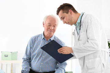 Doctor working with elderly patient in hospital