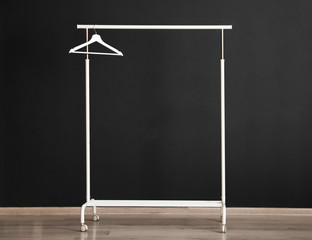 Wardrobe rack with hanger near dark wall