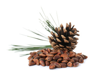 Heap of pine nuts and cone on white background
