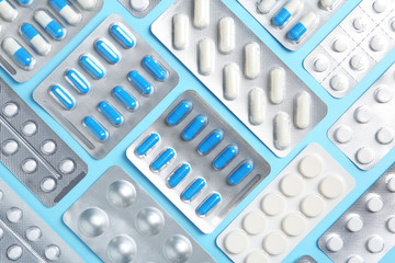 Flat lay composition with pills in blister packs on color background