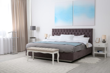 Fototapeta na wymiar Stylish room interior with large comfortable bed
