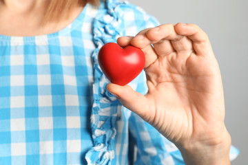 Woman holding red decorative heart, closeup view