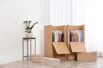 Wardrobe boxes with clothes near window indoors