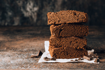 Homemade dark chocolate browniesstacked on dark table