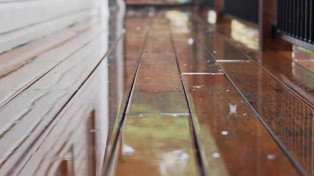 Wood deck walkway around a house in the rain with reflections