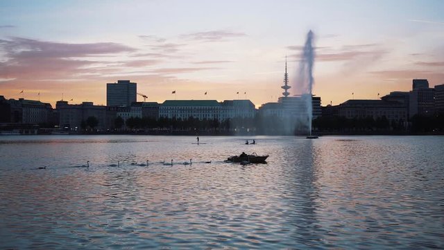 Schw&radic;&sect;ne begleiten ein Tretboot beim Sonnenuntergang an der Alster, Hamburg. Aufgenommen mit der Sony A7 III, Zeiss 35mm, 100FPS.