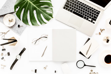 Home office workspace mockup with laptop, tropical leaves Monstera, clipboard, notebook and accessories on white background. Flat lay, top view