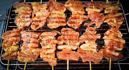 Delicious Grilled pork bamboo sticks on grille / Thai street food Barbecue toast pork