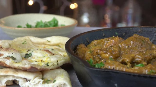 Chicken Korma. Traditional Indian Curry Dish Served in a Cast Iron with Basmati Rice and Garlic Naan
