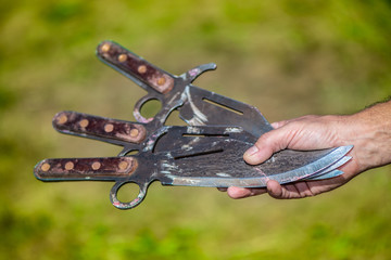 Hand holding three throwing knifes